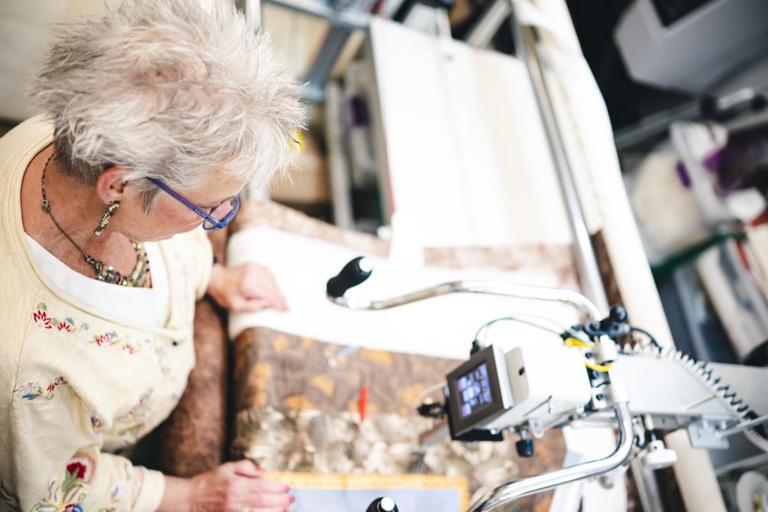 Anna Chupa stands with the longarm quilting machine in her studio.